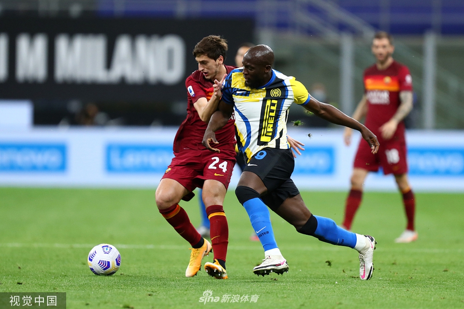 姆希塔良在进球后握拳怒吼，脸上露出坚毅的神情，身后的队友正准备上前庆祝，背景是客队球迷看台，气氛紧张而热烈。