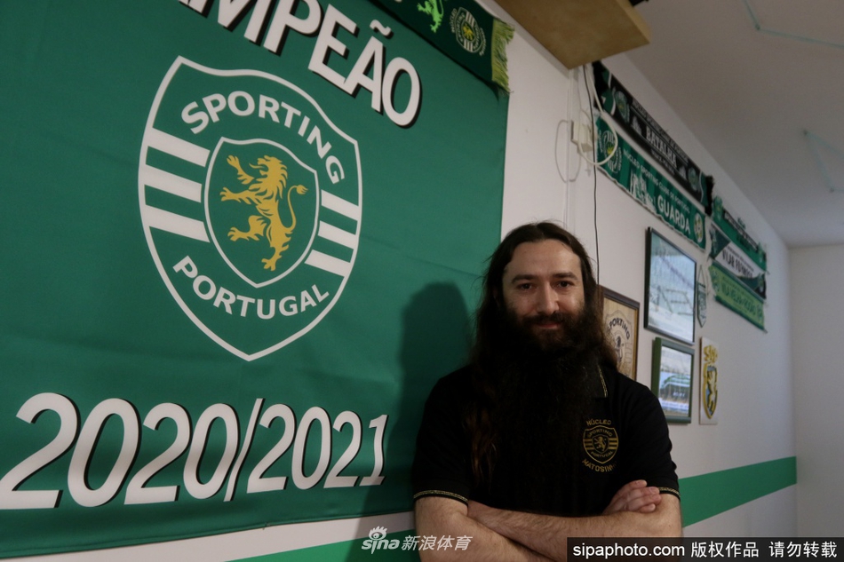 半张脸掩映在茂密的胡须之后，只露出一双深邃的眼睛。这双眼睛望向球场的方向，里面闪烁着坚定的光芒，仿佛能穿透时光，看见球队重新崛起的辉煌一刻。这浓密的胡须，就是他无声的誓言与忠诚的旗帜。