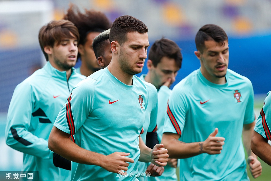 一名葡萄牙球员正迎着夕阳的余晖进行射门练习。皮球呼啸着离开他的脚面，在空中划出一道美丽的弧线直奔球门死角。背景是模糊的球场和看台，逆光勾勒出他健硕的肌肉线条，这张照片仿佛诉说着每一位球星背后，都是无数次枯燥而专注的重复。