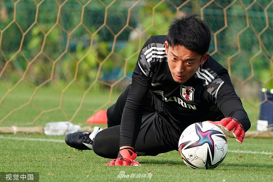 一名日本队球员正在进行单独的带球训练，他脚下的皮球仿佛被无形的线牵引，在标志碟之间灵活穿梭，展现出了极佳的个人技术和身体平衡能力。