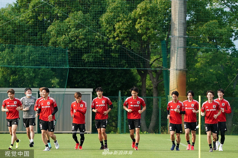训练间隙，几名日本队员围拢在一起，神情严肃地进行着交流。其中一人手指着远处的空档，似乎正在与队友分享自己对场上形势的观察，团队协作的精神在这一刻展露无遗。