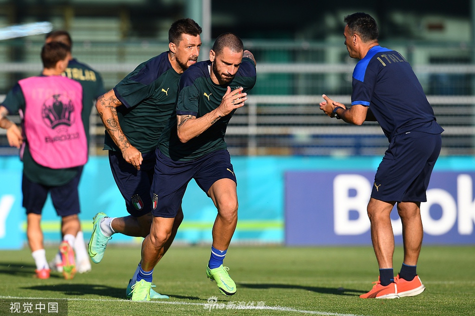 在罗马奥林匹克球场附近的训练场上，蓝衣军团的将士们正在进行赛前最后一练。阳光穿过云层，中场大师维拉蒂抬起手臂遮挡刺眼的光芒，眼神专注地望向教练席方向，仿佛在烈日下思考着如何用魔术般的双脚撕开瑞士人的防线。