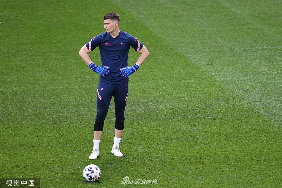 球场上，克罗地亚球员正在进行高强度的分组对抗，一名中场球员奋力铲抢，草皮随着他的动作飞溅起来，汗水已经湿透了他的球衣，显示出全队放手一搏的决心。