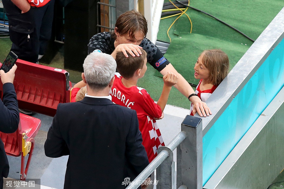 一位克罗地亚球员将女儿高高抱起，小女孩紧紧搂着父亲的脖子，球员原本紧锁的眉头在女儿的拥抱中舒展开来，画面充满温情。