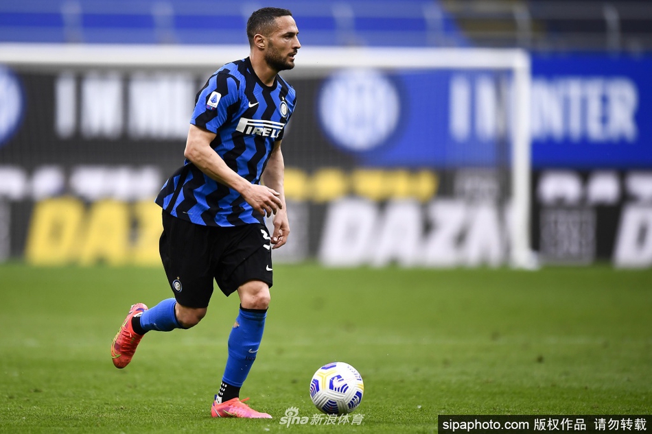 丹布罗西奥在成功续约后，于国际米兰俱乐部办公室内手持全新合约，脸上洋溢着满足而坚定的笑容，身后的蓝黑配色背景墙格外醒目。