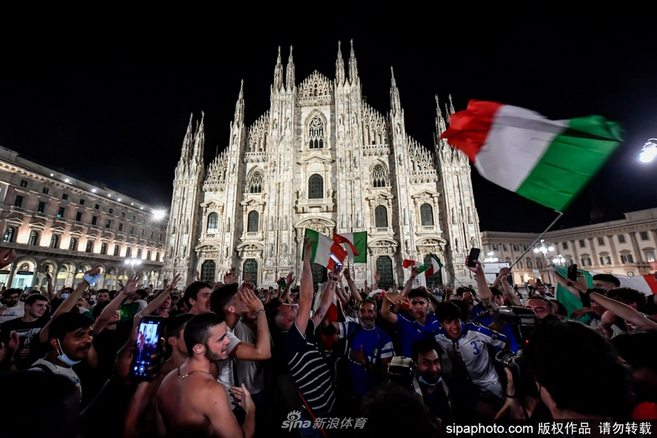 人潮涌动的米兰街头，无数面意大利三色旗在夜风中猎猎飘扬，球迷们挥舞着手臂，用最炽热的呐喊将通往决赛的夜晚染成狂欢的海洋。