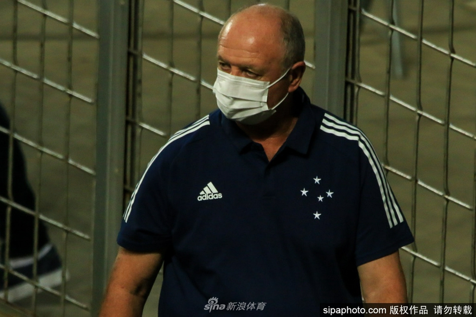 球场边的斯科拉里正在激情指挥比赛，他身体微微前倾，右臂奋力指向场内，仿佛要将自己的战术意志直接传递给场上的弟子。背景中虚化的看台和广告牌，衬托出他在危急时刻的全神贯注。