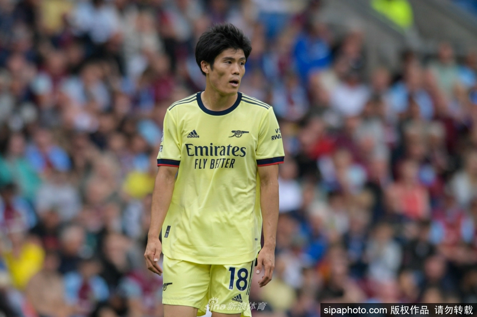 身披阿森纳红色战袍的富安健洋，在英超赛场上与对手球员腾空而起，他凭借着出色的弹跳和精准的判断，高高跃起抢到头球点，眼神坚毅地望向皮球飞行的方向。