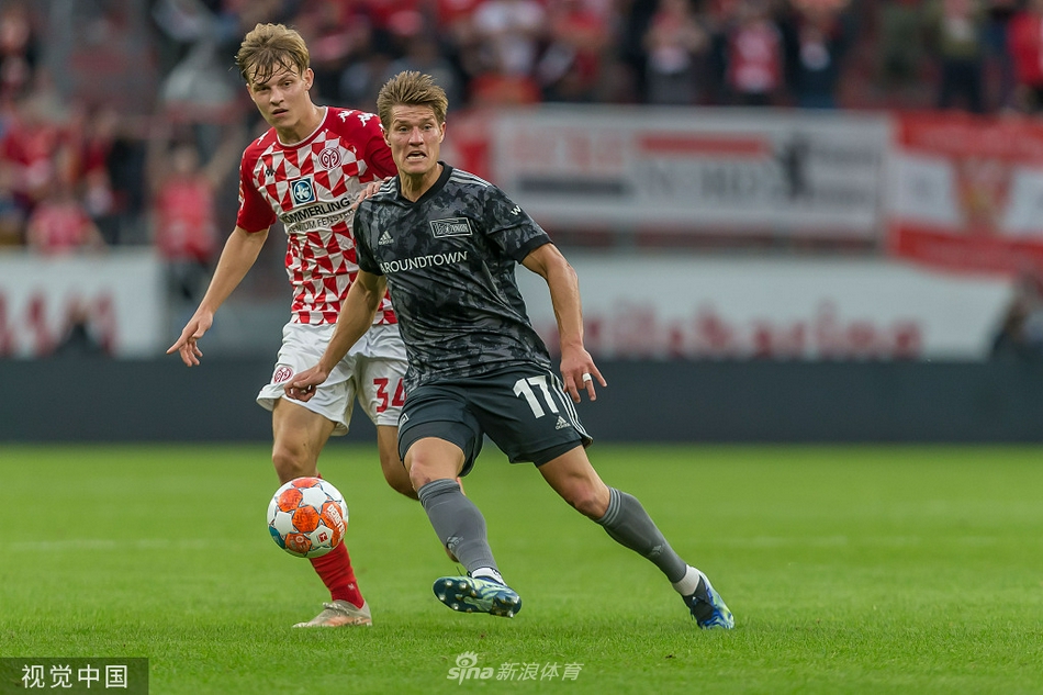 欧宝竞技场上空乌云密布，预示着这场德甲对决的激烈程度，美因茨球员身着红色战袍蓄势待发。