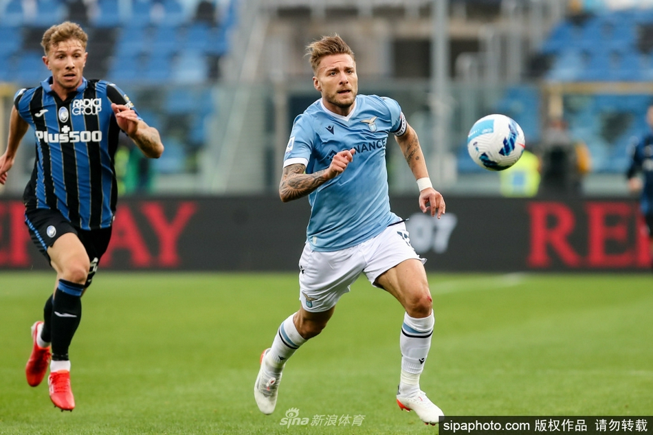 身披拉齐奥战袍的因莫比莱，目光如炬，在对方后卫的严密包夹下，高高跃起争抢头球，蓝色的球衣在空中舒展，仿佛一只翱翔的雄鹰，为了每一次进攻机会奋不顾身。