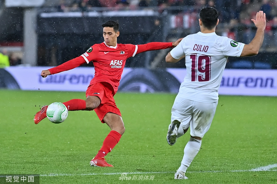 阿尔克马尔后卫球员在本方禁区内高高跃起，力压克卢日进攻球员完成了一次关键的争顶解围，他肌肉紧绷，展现出了强大的核心力量和必胜的决心。