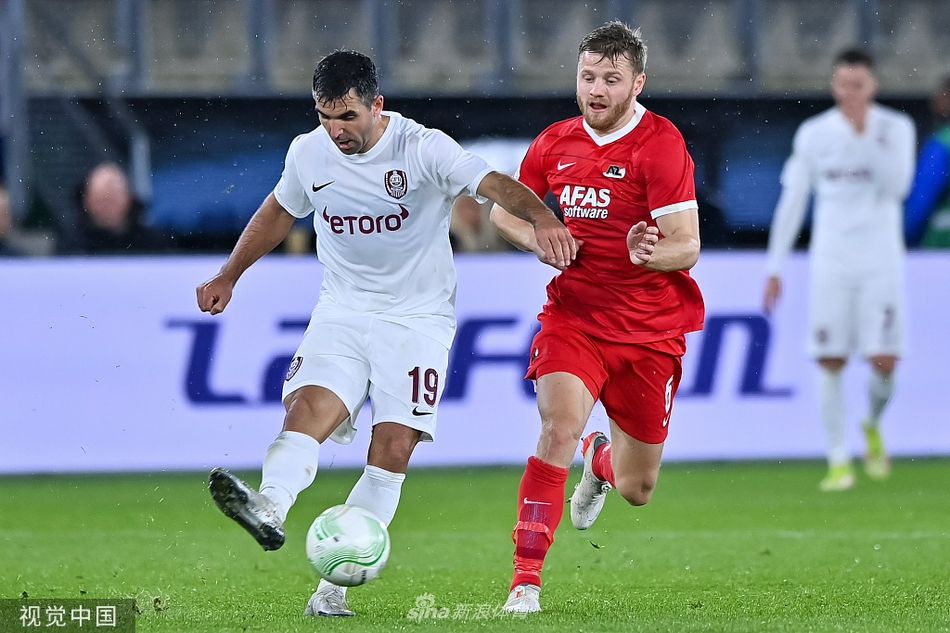 克卢日的中场发动机胡安·库利奥正在奋力拼抢，他张开手臂试图护住皮球，眼神坚毅地盯着前方，身边的阿尔克马尔球员则寸步不让，展现出中场争夺的激烈程度。