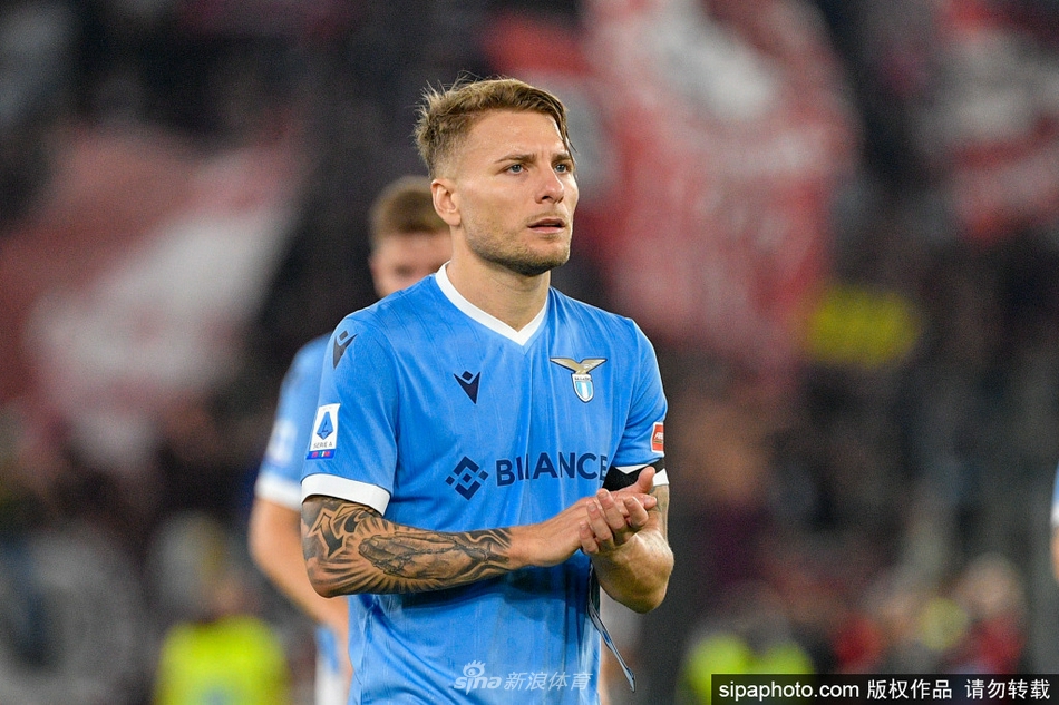 因莫比莱在进球后张开双臂激情奔跑，他的眼神坚定地望向前方，仿佛要拥抱整个奥林匹克球场的欢呼声，蓝色的战袍在风中鼓胀，如同猎鹰展翅翱翔。