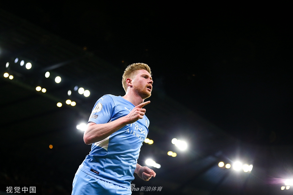 曼城众将在伊蒂哈德球场激情庆祝进球，背景中兴奋的球迷汇成一片蓝色海洋