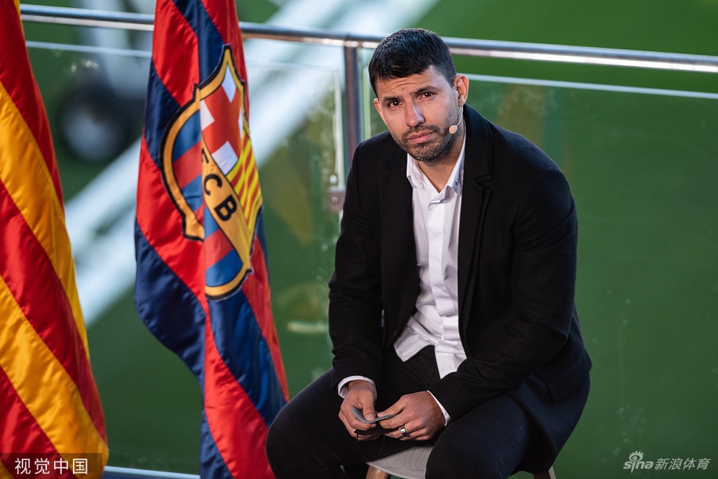 阿圭罗与现场人员交流，手势坚定，仿佛在阐述他面对未来的决心与计划。