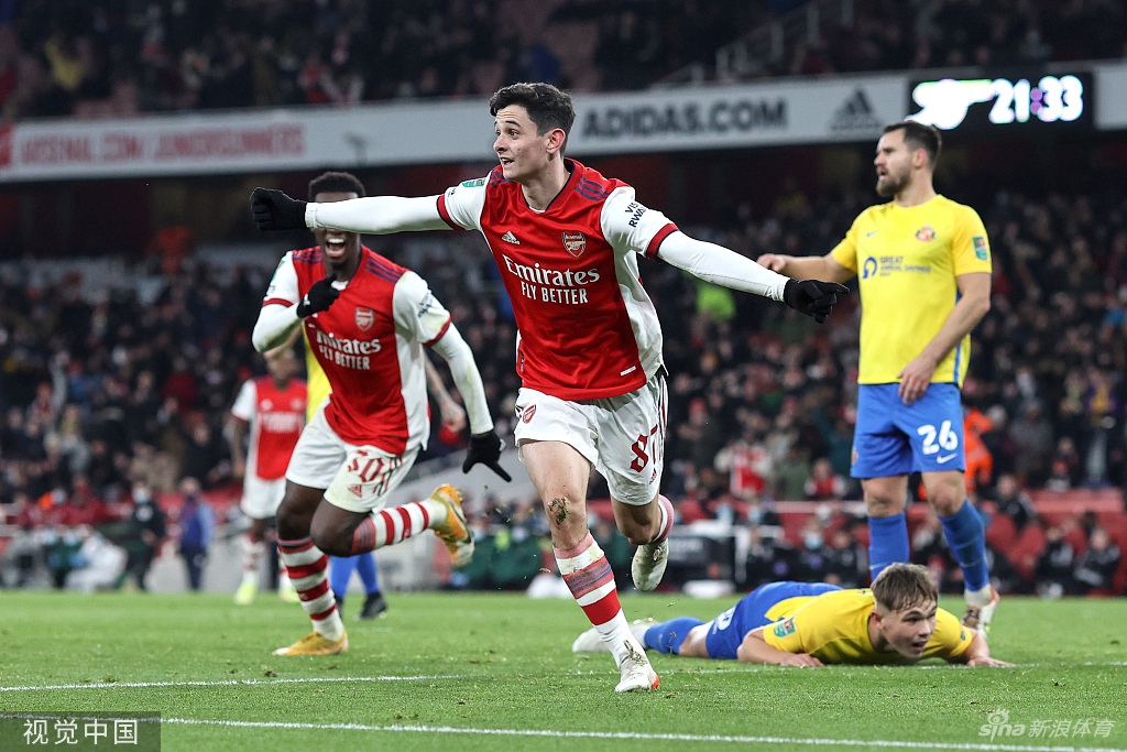 更衣室内恩凯蒂亚手持比赛用球，被簇拥在中央接受全队的祝贺