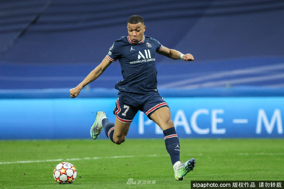 姆巴佩在万众瞩目下庆祝进球，张开双臂尽情释放激情，身后是模糊的狂热球迷背景。