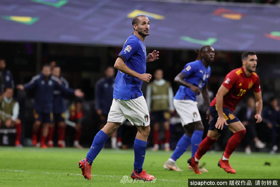 基耶利尼与队友在训练中专注交流，手臂上的意大利队长袖标象征着责任与传承。