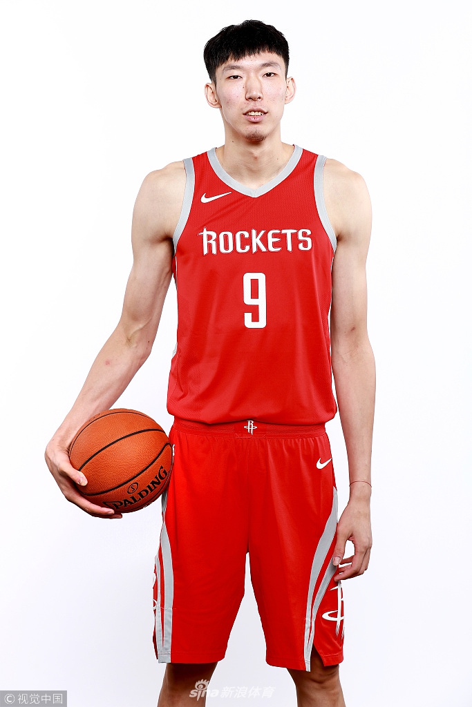 周琦穿着训练服，在场边露出腼腆而自信的微笑，仿佛那个从河南新乡走出的篮球少年，依然怀揣着最初的梦想，无论前路几何。