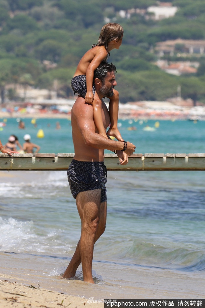 博阿斯身穿深色泳裤，独自站立在海边，目光深邃地望向远方，身后是波光粼粼的地中海，仿佛在沉思新赛季的欧冠征程。