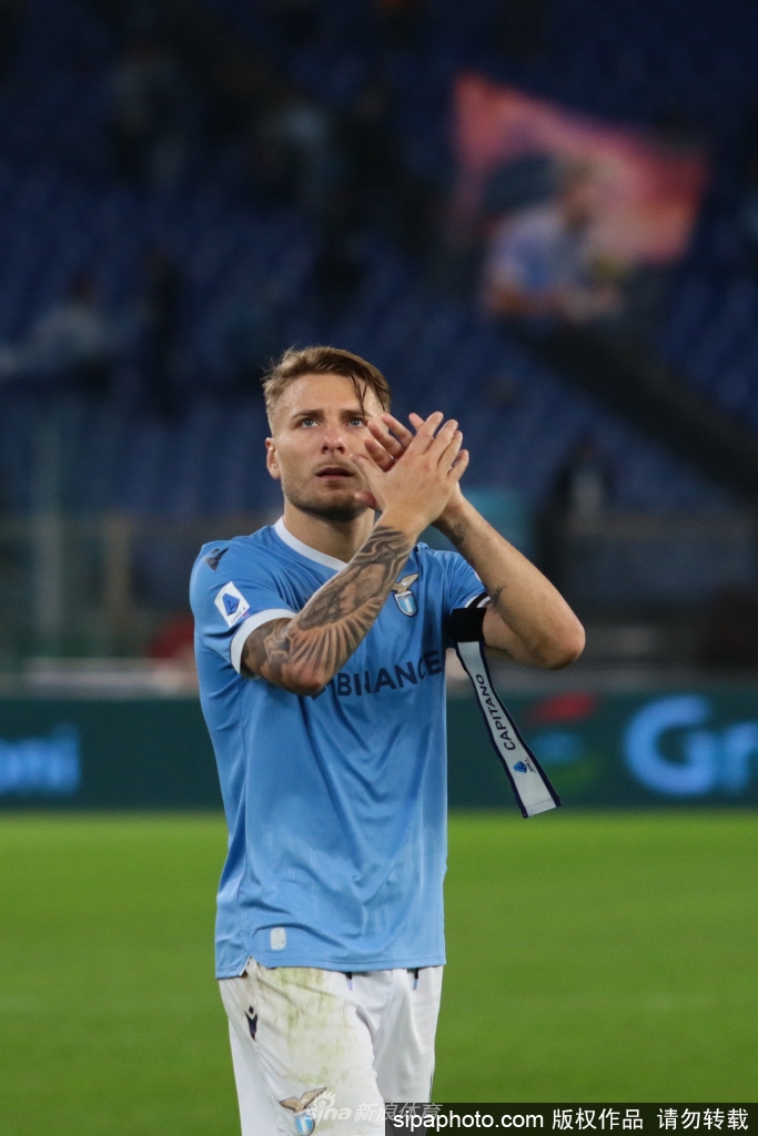 进球后的因莫比莱单膝跪地，紧握右拳奋力挥向天空，脸上的青筋因怒吼而微微暴起，全身的肌肉线条在紧绷的球衣下勾勒出力量的美感，仿佛一头正在宣示领地的主权雄狮。