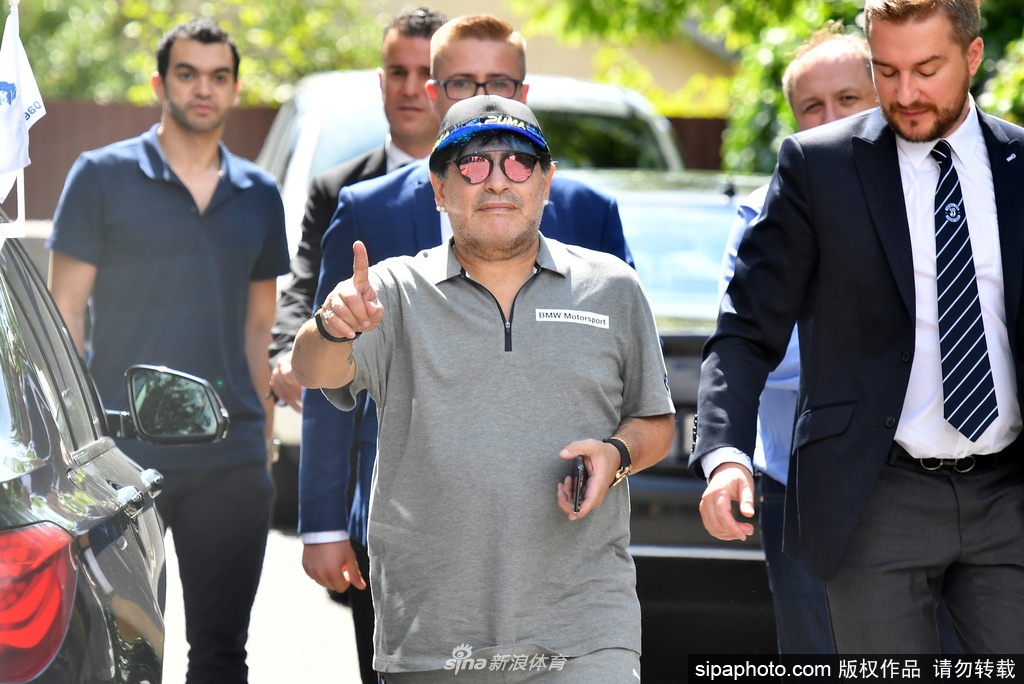 球王马拉多纳在续约发布会上，面对镜头露出孩子般的灿烂笑容，那双曾征服世界的手，此刻紧握着象征信任的蓝白围巾。