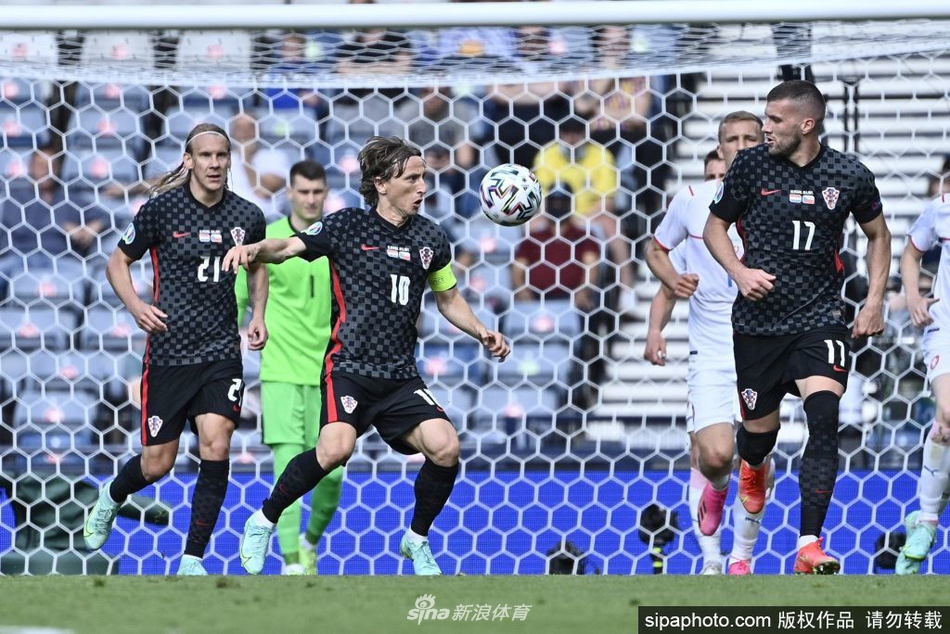 在中场激烈的拼抢中，莫德里奇以他标志性的低重心和精湛的控球技术，护住皮球，眼神坚定地观察着场上的局势。