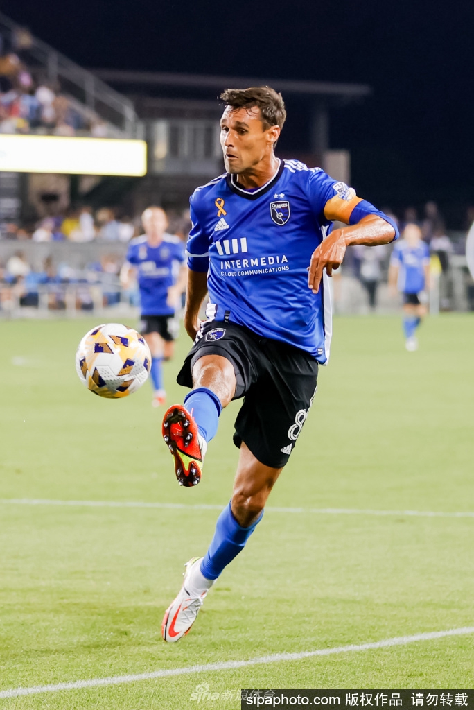 在一场雨战中，万多洛斯基挥拳怒吼庆祝进球，雨水与汗水交织在他坚毅的脸庞上，身后是沸腾的看台和飞舞的旗帜，定格了他职业生涯中最具代表性的激情瞬间。