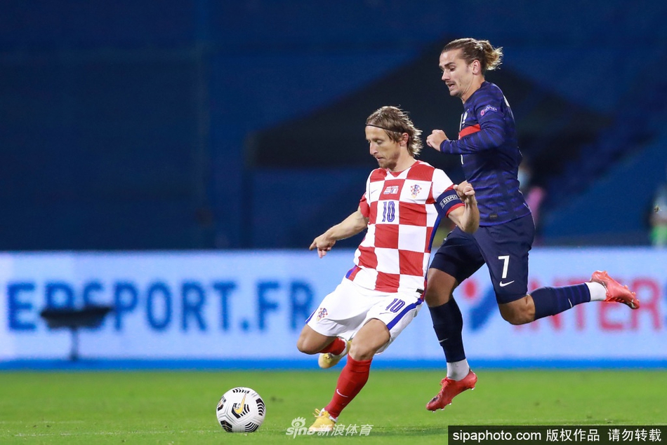 莫德里奇在对手的严密包夹下轻盈起舞，他用一次极具想象力的转身护球，瞬间摆脱了葡萄牙防守球员的纠缠。湿滑的草皮溅起泥点，却无法沾染他此刻掌控全局的从容与优雅。