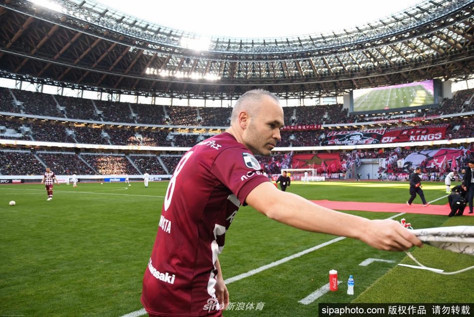 在新闻发布会的主席台上，伊涅斯塔身穿笔挺的西装，伸手轻抚着即将签下的续约合同，身旁的鲜花映衬着他平和而坚定的神情