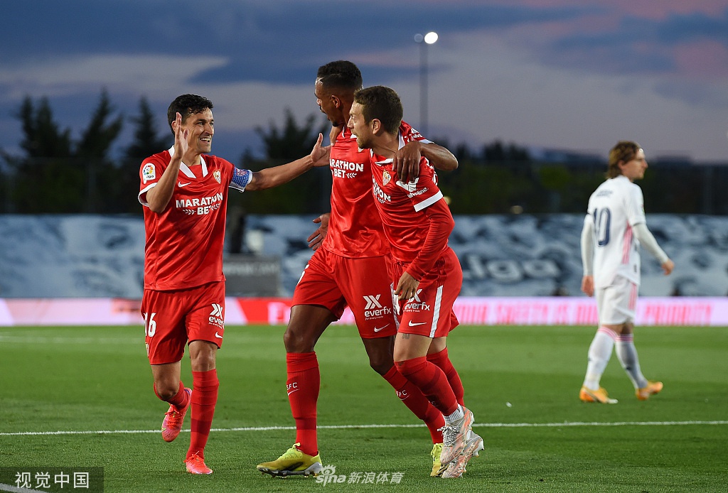 阿森西奥张开双臂滑翔庆祝，他的球衣被风鼓起，脸上写满了难以置信的惊喜，队友们正从四面八方冲向他。