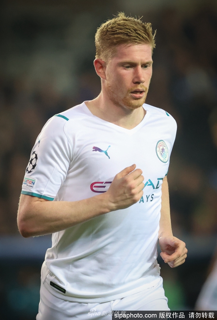 德布劳内高举英超冠军奖杯，笑容灿烂，身旁的蓝色纸屑如雨落下，庆祝着又一个荣耀巅峰