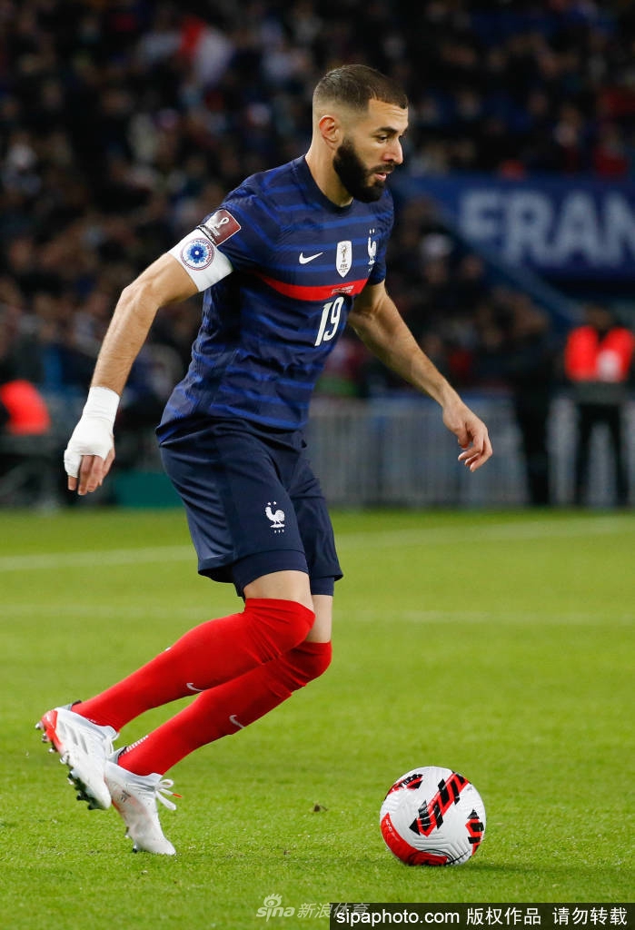 本泽马面带沉稳微笑，手指轻抚《法国足球》杂志封面上自己的肖像，尽显从容与满足