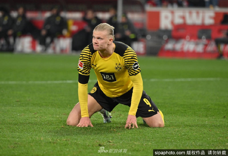 哈兰德身穿曼城训练服，在训练场上自信微笑，眼神中充满了对新征程的期待