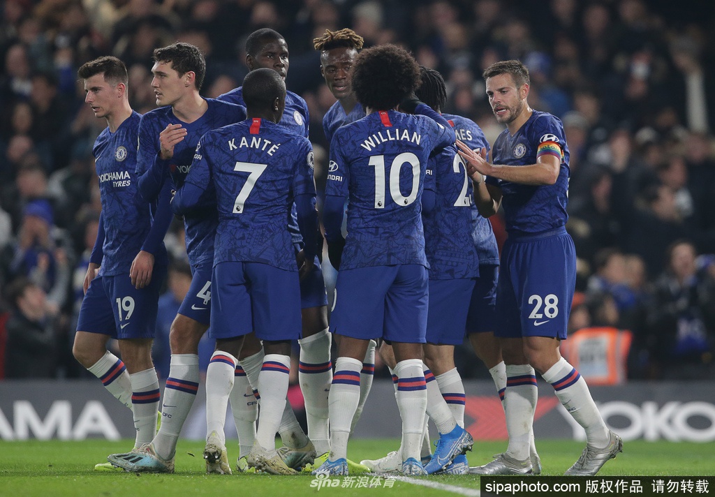 从高处俯瞰斯坦福桥球场，绿茵场在空旷的六万座席环抱下显得格外宁静，只有教练席和替补席的座位上整齐摆放着蓝色的训练背心和水瓶，暗示着这里仍有战斗在悄然准备。