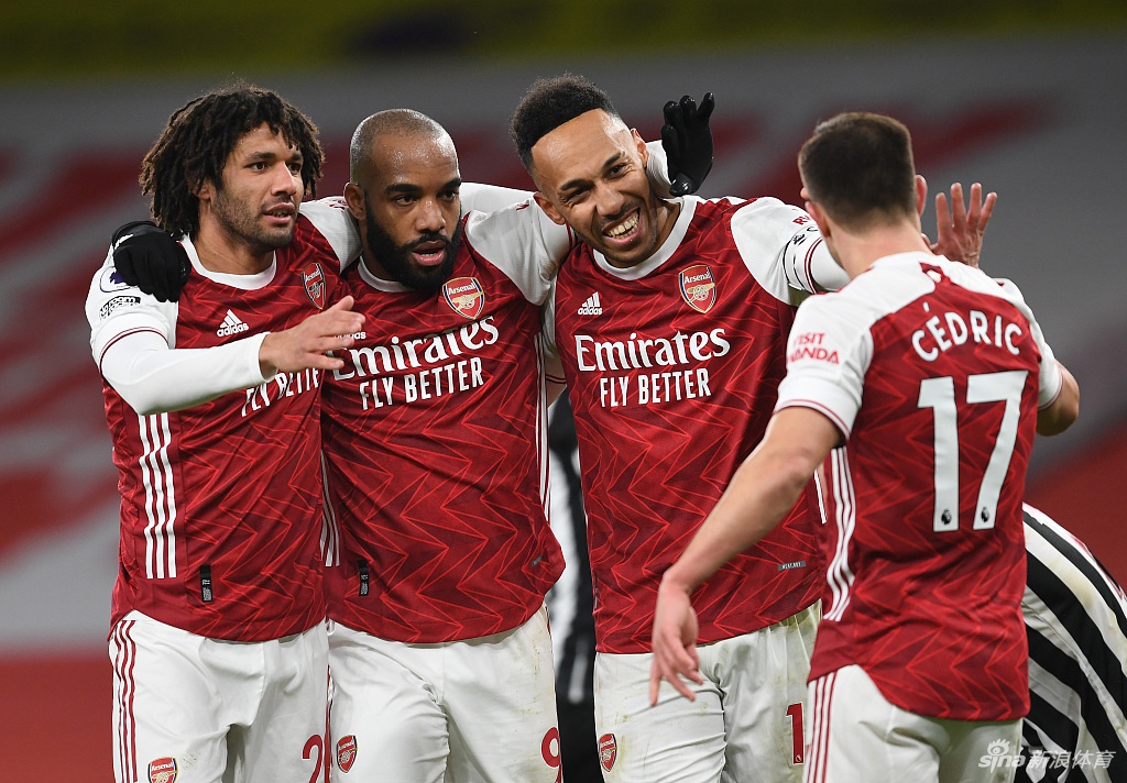 奥巴梅扬在进球后激情滑跪，草屑飞舞，酋长球场看台上掀起红白色的狂欢浪潮