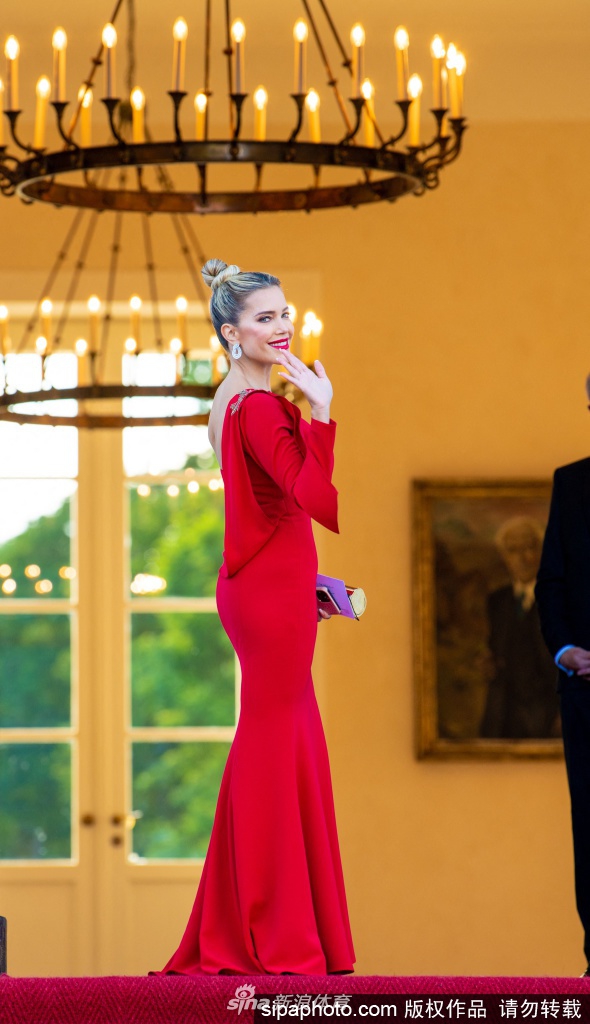 西尔维·梅斯红毯上从容面对镜头，红色单肩礼服裙摆及地，背景的柏林夜色与她灿烂的金发形成鲜明对比，定格了2021年夏天最优雅的瞬间。