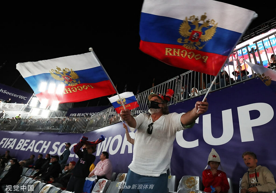 俄罗斯队球员在防守中高高跃起，与日本队员进行激烈的头球争顶，肌肉的碰撞和专注的眼神彰显比赛的紧张程度。