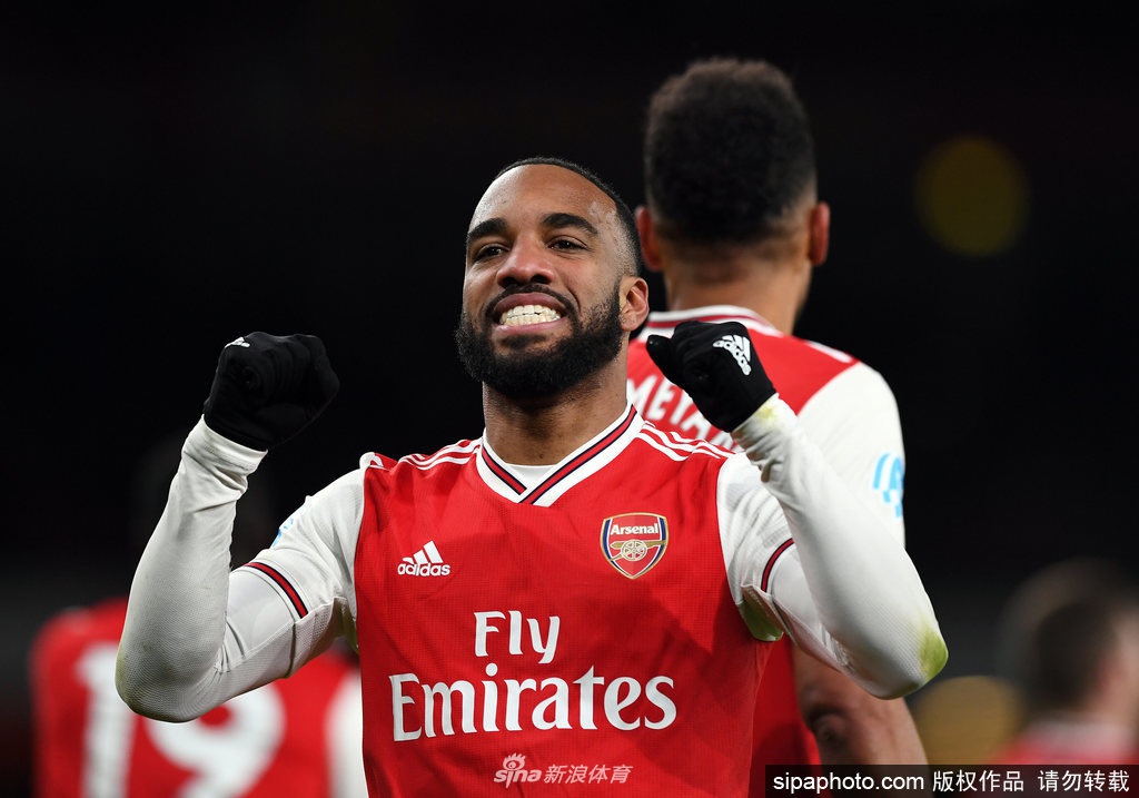 英超赛场上，九名替补球员与主教练共同坐在看台替补席，神情专注地等待召唤