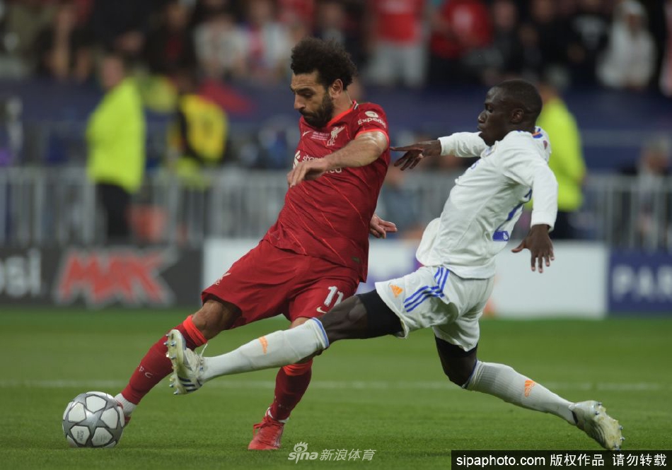 萨拉赫在比赛中带球突破，对手后卫紧追不舍的激烈瞬间