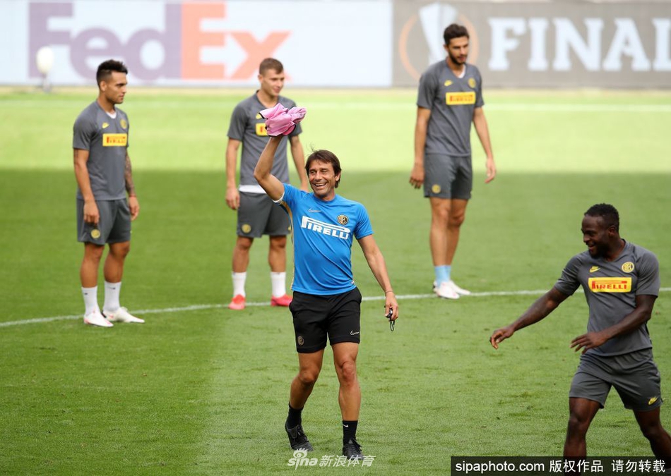 在苏宁训练中心开阔的绿茵场上，国际米兰的球员们正慢跑进行热身，他们身后是湛蓝的天空和茂密的树林，整个画面充满了清晨的活力与备战新赛季的宁静氛围。