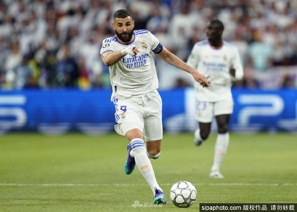 本泽马手捧欧冠最佳球员奖杯，面带沉稳微笑，眼中闪烁着实现终极梦想的满足与荣耀之光