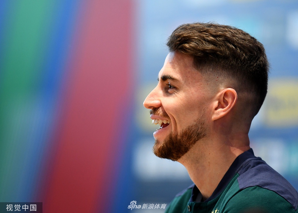 发布会现场全景，若日尼奥在台上从容应对记者提问，台下坐满了戴着口罩的媒体人员，大家保持着安全距离，专注地记录着每一个关键信息，共同构成了疫情下足球大赛的独特画面。