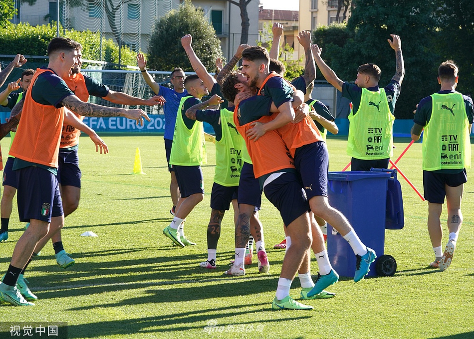 意大利全队围成圆圈进行抢圈游戏，背景里的训练器材静静矗立，见证着蓝衣军团的轻松时刻