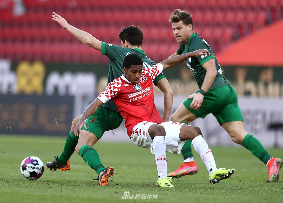 美因茨前锋绍洛伊背身护球，身后的奥格斯堡后卫乌多凯寸步不让，两人手臂纠缠在一起，仿佛一场力量与技巧的无声博弈在此刻上演。