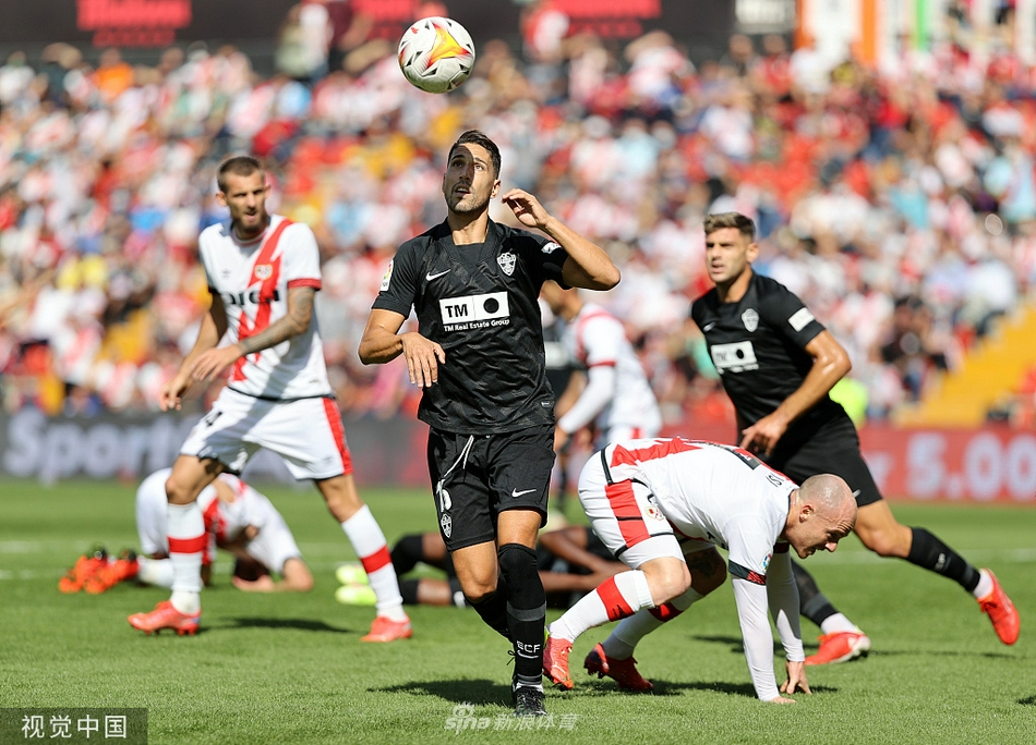 巴列卡诺与埃尔切球员在场上激烈拼抢，主队球员正试图用身体卡住位置，足球在双方脚下一度形成混战，现场气氛紧张至极。