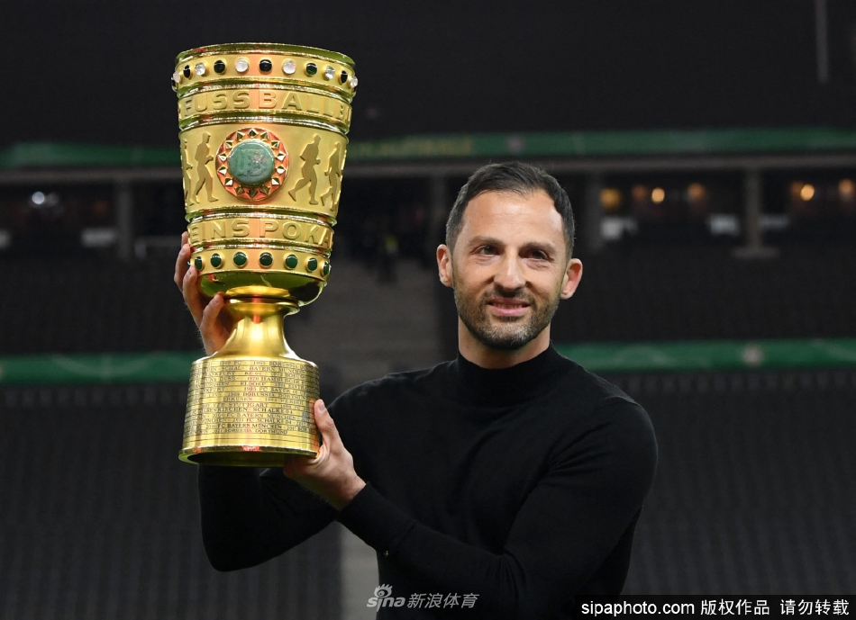 少帅特德斯科高举德国杯冠军奖杯，与身后激动的莱比锡球员共同庆祝队史首座职业赛事桂冠