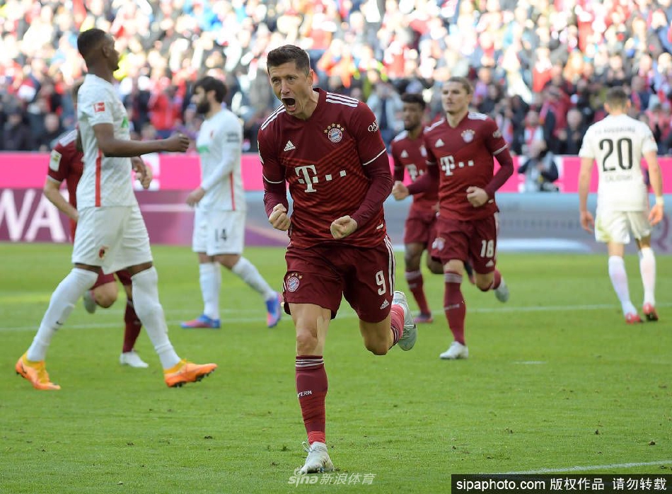 莱万手持巴萨围巾向球迷展示，脸上洋溢着自信与期待的笑容，背后是俱乐部的巨大徽章，象征着一段红蓝传奇的正式启航。