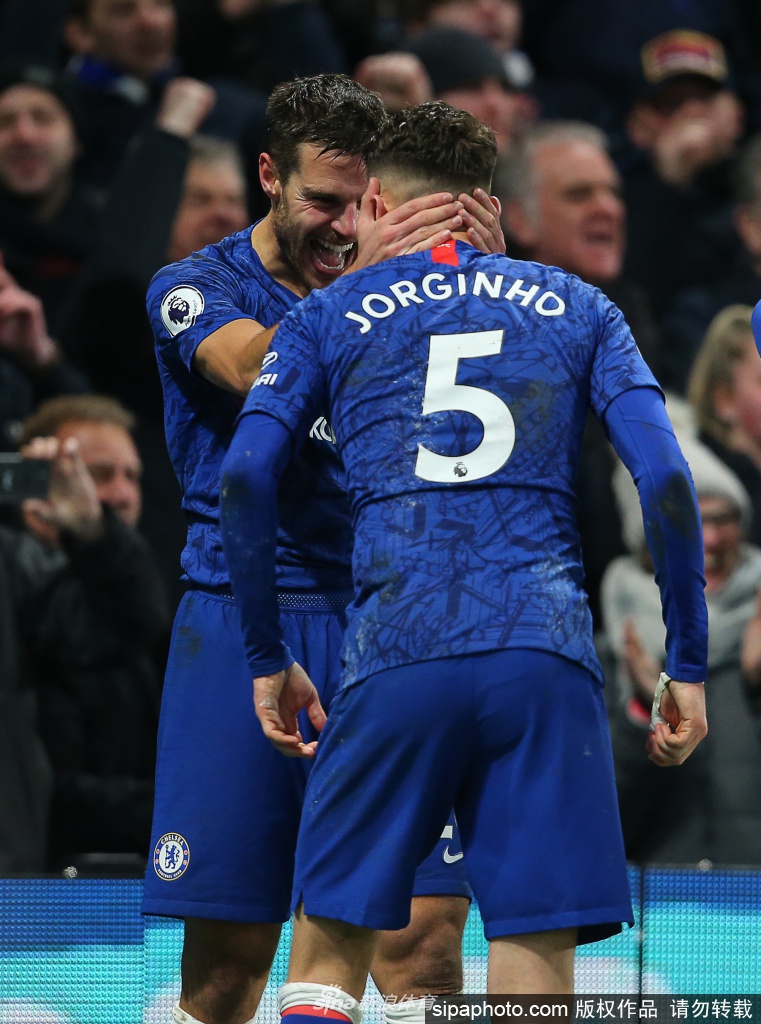 进球后的若日尼奥张开双臂尽情奔跑庆祝，身后的斯坦福桥球场看台上旗帜飘扬，队友们纷纷向他聚拢，整个球场瞬间被点燃，欢呼声震耳欲聋。