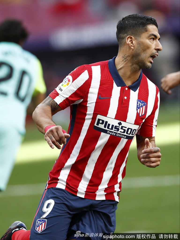 苏亚雷斯张开双臂奔跑在绿茵场上，阳光勾勒出他坚毅的面部轮廓，他的目光望向远方的冠军奖杯，仿佛在拥抱整个马德里竞技的世界。